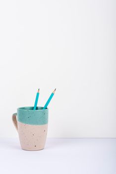 Cup With Two Same Pencils Inside Placed On Office Desk.