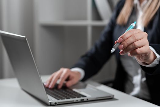 Woman Typing Updates On Lap Top And Pointing New Ideas With Pen.