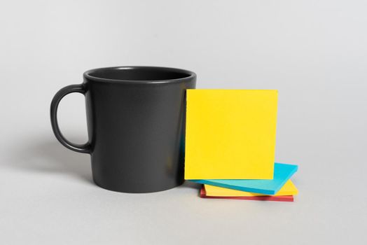 Cup And Pile Of Sticky Notes With Important Information On Desk.