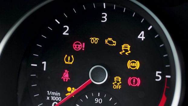 Many different car dashboard lights with warning lamps illuminated. Light symbol that pops up on dashboard when something goes wrong with the engine.