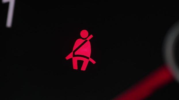 Car seat belt indicator lights on dashboard. Road safety regulations concept.