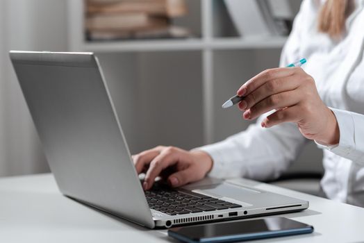 Woman Typing Updates On Lap Top And Pointing New Ideas With Pen.