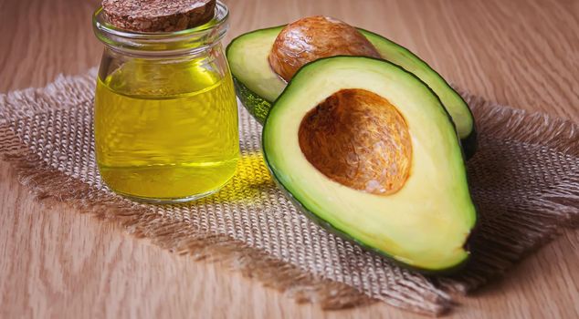 Avocado and avocado oil on wooden background. Selective focus.food