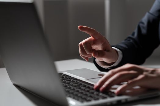 Woman Typing Updates On Lap Top And Pointing New Ideas With One Finger.