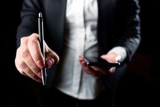 Businesswoman Holding Cellphone And Pointing Important Ideas With Pen.