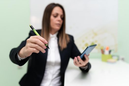Woman Holding Tablet And Pointing Important Informations With Pen In Hand.