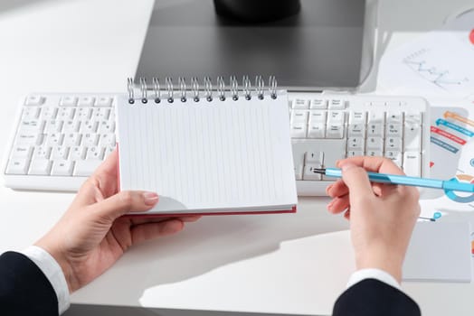 Woman Holding Notebook With New Ideas Over Desk With Computer And Keyboard.