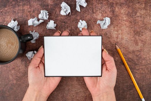 Hands Of Woman Holds Sheet With Coffee Cup, Pencil And Crumpled Papers.