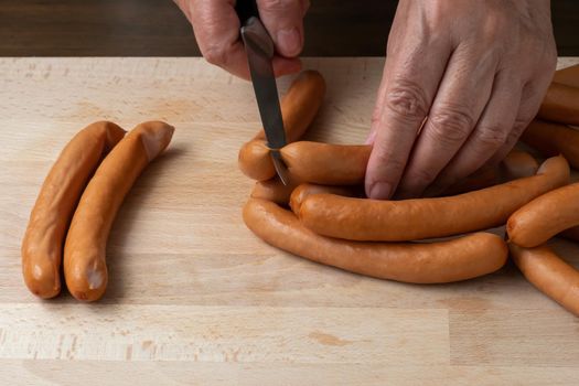 Thin pork sausages on the wooden cutting board