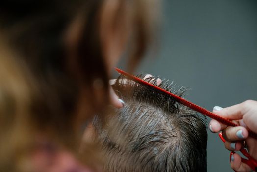 men haircut. hairdressing tools. hair cutting with scissors close-up.Close up of a haircut at a hair saloon