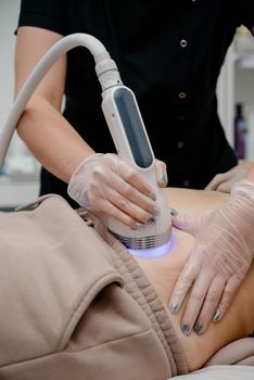 A woman in a beauty salon receives a vacuum abdominal massage, Hardware cosmetology.Hardware cosmetology for skin care and body contouring