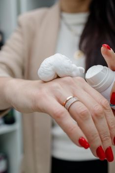 Close up of hands of woman preparing to apply gentle foam facial cleanser.Skin foam