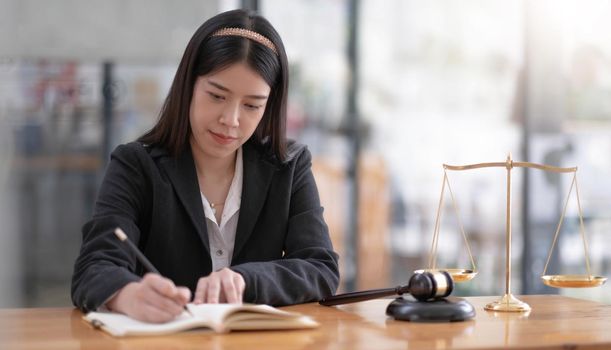 Business and lawyers discussing contract papers with brass scale on desk in office. Law, legal services, advice, justice and law concept picture with film grain effect.