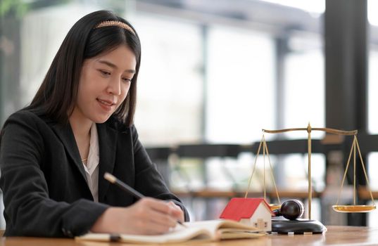 Business and lawyers discussing contract papers with brass scale on desk in office. Law, legal services, advice, justice and law concept picture with film grain effect.