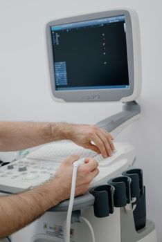 The doctor uses an ultrasound device to study the condition of the veins.Modern ultrasound monitor. Ultrasonography machine. High technology medical and healthcare equipment.