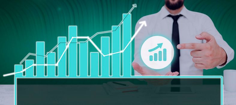 Businessman Pointing On A Chart Showing Crucial Diagrams And Data.