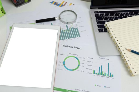 Document graph and chart report financial investment marketing with mock up white screen blank tablet on desk business concept.