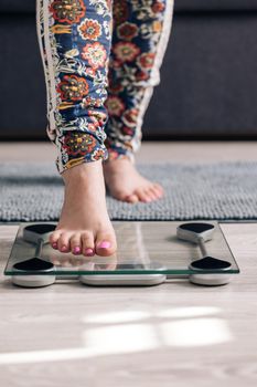 Person steps on the digital scales to check her weight. Inscription Help on a digital display. Aboveoverweight woman is weighed on a scale close up. Diet.