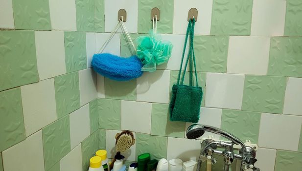 Synthetic washcloths for body care hang on the wall in the bathroom.