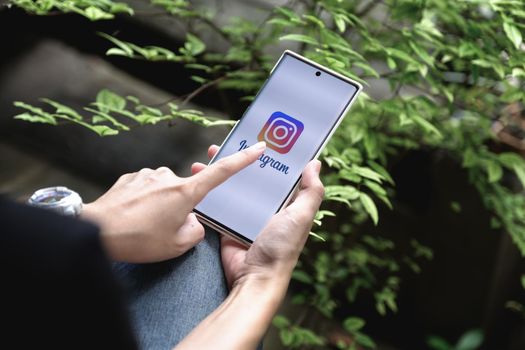 CHIANGMAI, THAILAND - July 09, 2021: A woman holding smartphone with Instagram application on the screen. Instagram is a photo sharing app for smartphones