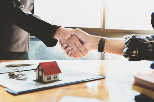 Focus on the congratulatory handshake. The real estate agent agrees to buy the home the customer at the agent's office. concept agreement