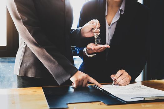 Real estate agents agree to buy a home and give keys to clients at their agency's offices. Concept agreement