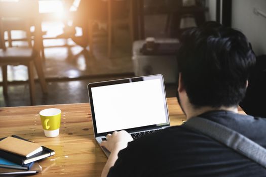 freelance concept, man using computers laptop on wooden desk blur background. Laptop computer with blank screen and can be add your texts or others on screen