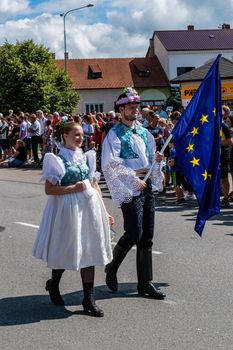 Straznice, Czech Republic - June 25, 2022 International Folklore Festival.Boy and girl with the EU flag in folk costumes