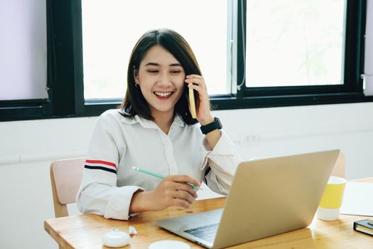 freelance concept,female using mobile phone and computers to design work as ordered by customers