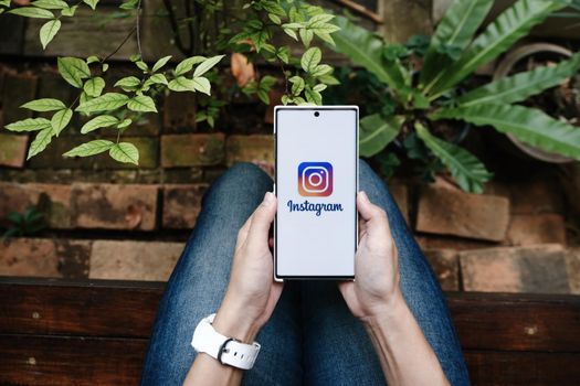 CHIANGMAI, THAILAND - July 09, 2021: A woman holding smartphone with Instagram application on the screen. Instagram is a photo sharing app for smartphones