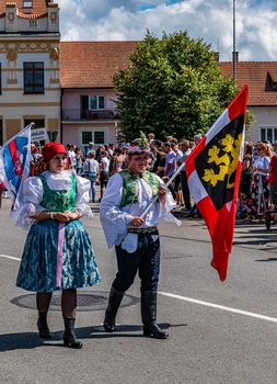 Straznice, Czech Republic - June 25, 2022 International Folklore Festival. A boy and a girl carry a flag in a costumed procession