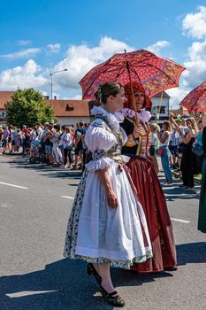 Straznice, Czech Republic - June 25, 2022 International Folklore Festival. Women in folk costumes with parasol with folk motifs