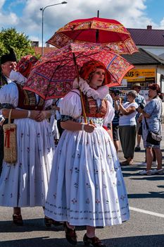 Straznice, Czech Republic - June 25, 2022 International Folklore Festival. Women in folk costumes with parasols with folk motifs