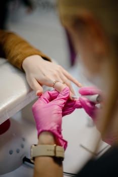 Manicurist makes hardware manicure close-up. Treatment of nails with the help of hardware manicure close-up