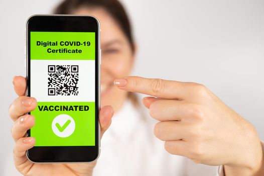 Woman showing smartphone with qr code about vaccination