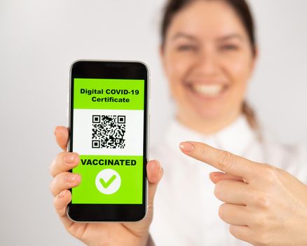 Woman showing smartphone with qr code about vaccination