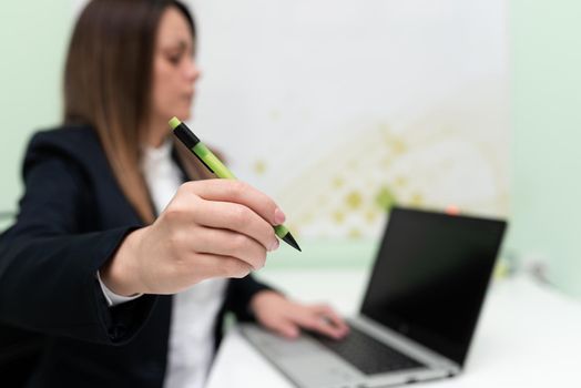 Woman Typing Updates On Lap Top And Pointing New Ideas With Pen.