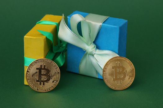 Two gift boxes with bows and bitcoin coins on a green paper background.