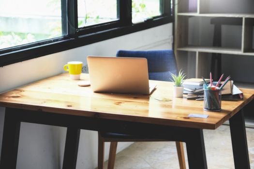 focus computer laptop with notebook and document on wood desk at home, vintage effect