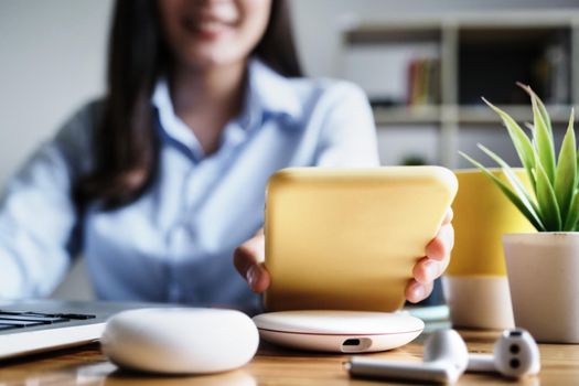 focus Female hand holding Smartphone to Charging at Wireless fast Charging pad at work. vintage tone