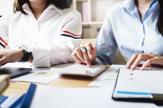 focus hand using calculator, Two young business executives are discussing to change their business concept to increase profits and the strength of their business with using calculator for work