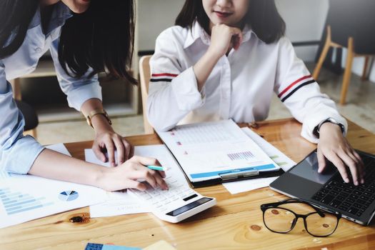 focus hand using calculator, Two young business executives are discussing to change their business concept to increase profits and the strength of their business with using calculator for work