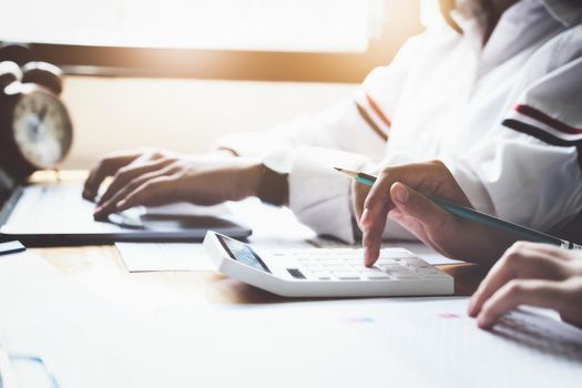 focus hand using calculator, Two young business executives are discussing to change their business concept to increase profits and the strength of their business with using calculator for work