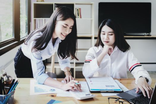 focus hand using calculator, Two young business executives are discussing to change their business concept to increase profits and the strength of their business with using calculator for work