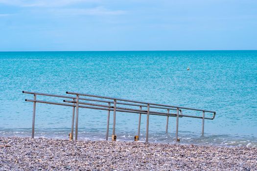 Handicapped metal chrome water guard rail outdoor sea shining blue, for waves railing from design from construction safety, europe black. Bulgaria ocean pier,