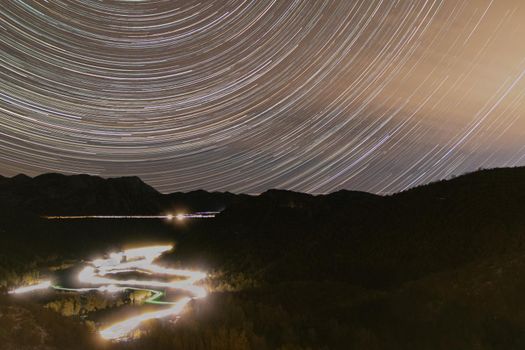 Star trail looking over the Rijeka Crnojevica river leading to Lake Skadar. Long exposure of stars circling Polaris North Star, over the river, Rijeka Crnojevica, leading to Lake Skadar, Montenegro.