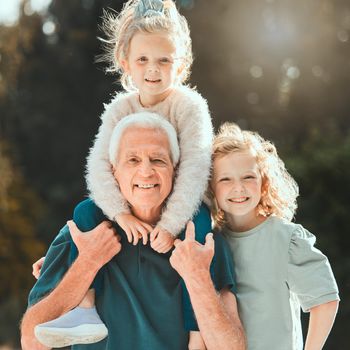 a senior man spending time with his grandchildren outside.