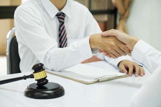 Businessman Shaking hands with Professional male lawyer after discussing good deal of contract in courtroom, Concepts of law, Judge gavel with scales of justic, Legal services advice at the law office.