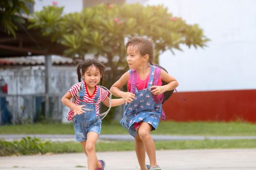 Happy smiling little girls with backpack running to school for the first time. Children are Happy and ready to learn. Back to school.