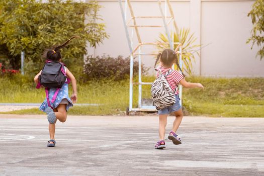 Happy smiling little girls with backpack running to school for the first time. Children are Happy and ready to learn. Back to school.